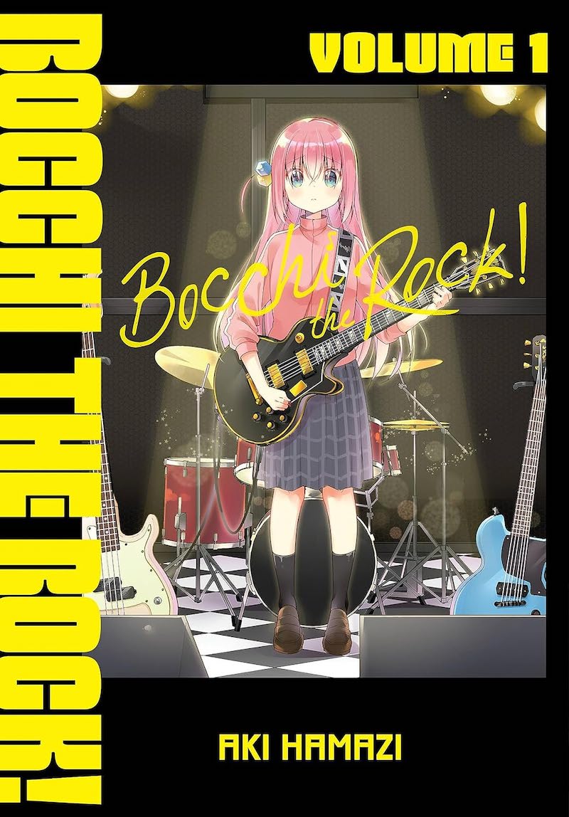 Cover of Bocchi the Rock!, showing a pink-haired girl standing on a stage, in the center of a spotlight, holding a guitar with a drum set behind her.
